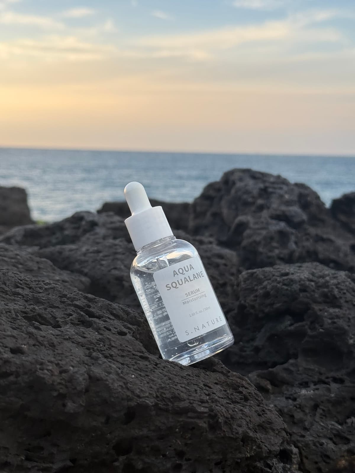 Serum bottle on coastal rocks